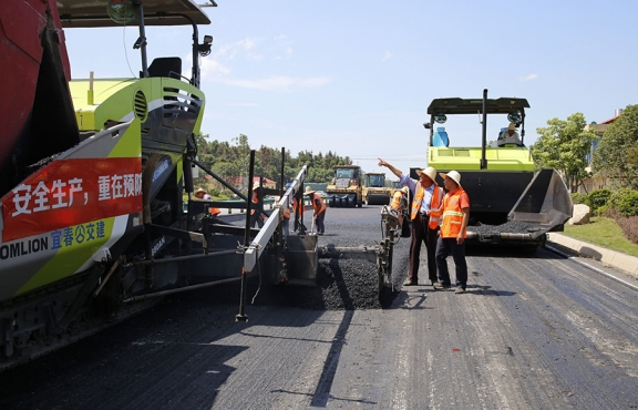 攤鋪機(jī)、壓路機(jī)等設(shè)備緊張有序運(yùn)行，高達(dá)170℃的瀝青混合料炙烤著公路人